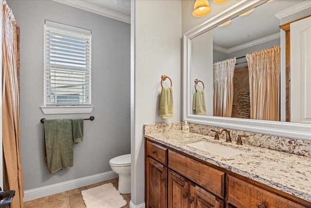 bathroom with toilet, baseboards, vanity, and crown molding