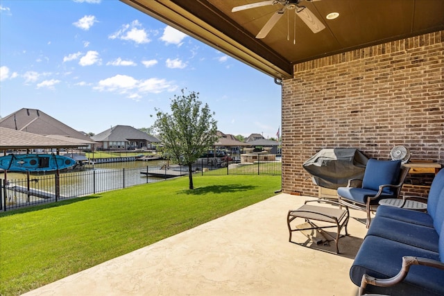 view of patio / terrace featuring a water view, grilling area, fence, a residential view, and ceiling fan