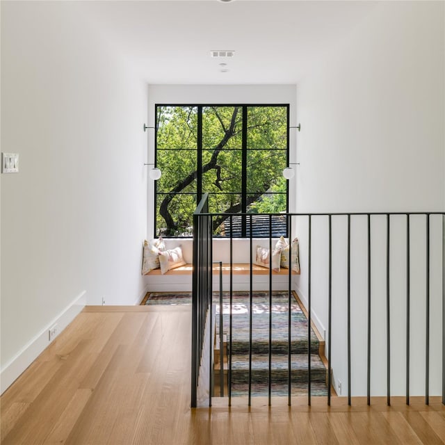 doorway featuring baseboards, visible vents, and wood finished floors