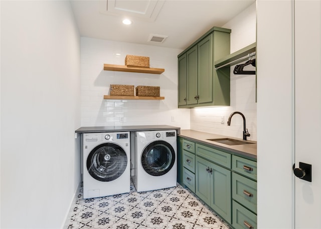 washroom with cabinet space, washer and dryer, visible vents, and a sink