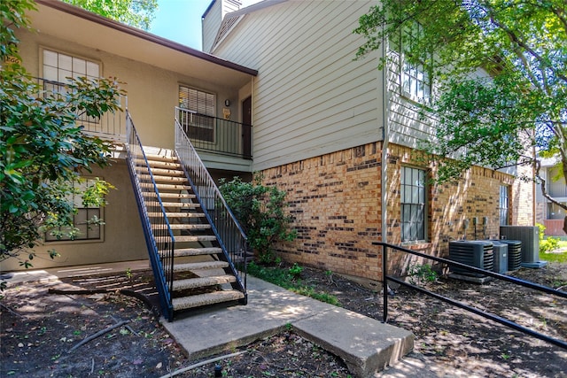 5335 Bent Tree Forest Dr Unit 267, Dallas, TX 75248 - view of side of home with central air condition unit, stairs, and brick siding