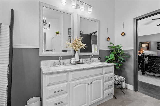 full bath featuring baseboards, a sink, and double vanity