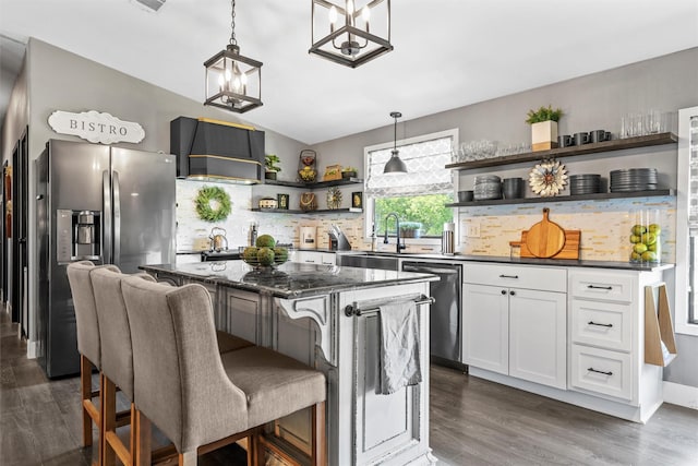 kitchen featuring white cabinets, stainless steel appliances, a sink, decorative backsplash, and open shelves