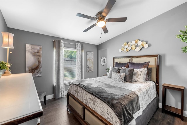 bedroom featuring dark wood finished floors, baseboards, lofted ceiling, and a ceiling fan