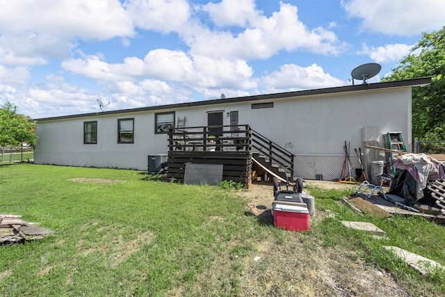 rear view of house featuring central air condition unit, fence, a wooden deck, a lawn, and stairs