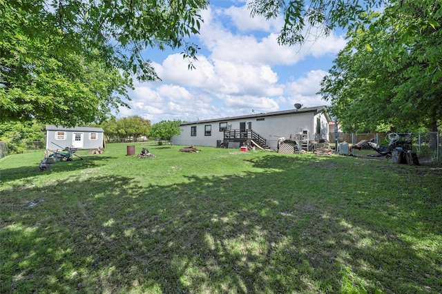 view of yard featuring an outbuilding, a fenced backyard, and stairway