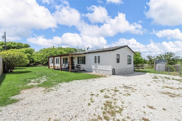 back of property featuring fence, a lawn, and a patio