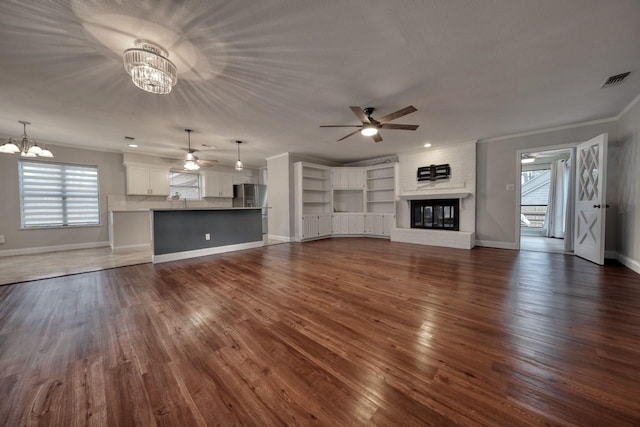 1208 Lake Cross Rd, Hideaway, TX 75771 - unfurnished living room with dark wood finished floors, baseboards, ornamental molding, and ceiling fan with notable chandelier