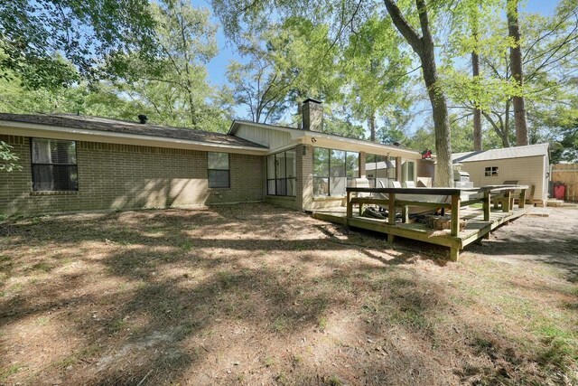 1208 Lake Cross Rd, Hideaway, TX 75771 - back of house with brick siding, a sunroom, a wooden deck, and a chimney