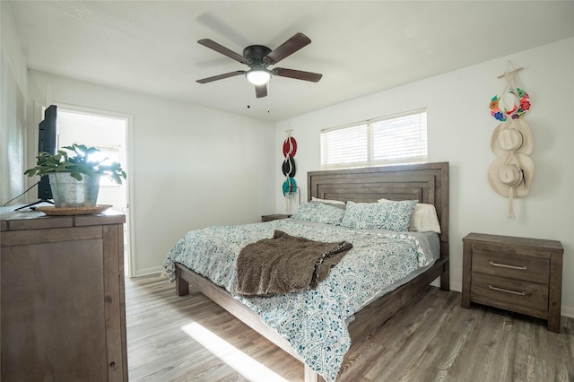 bedroom featuring wood finished floors, a ceiling fan, and baseboards