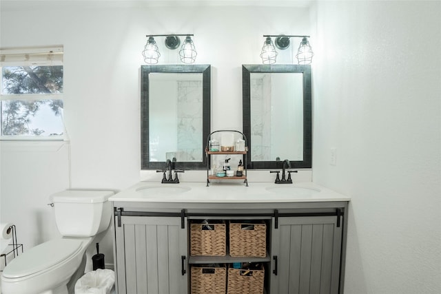 bathroom featuring a sink, double vanity, and toilet