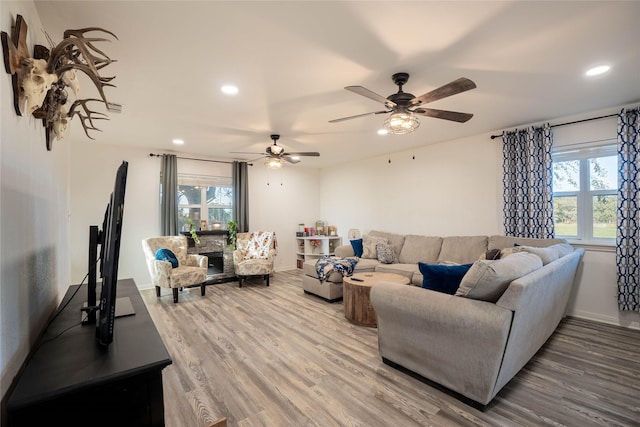 living room with plenty of natural light, a ceiling fan, wood finished floors, and recessed lighting