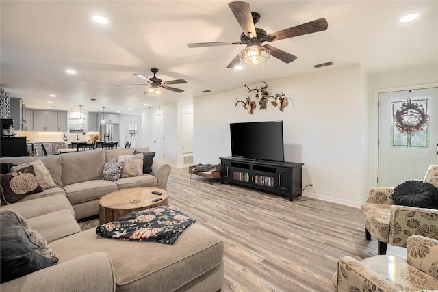 living area with a ceiling fan, light wood finished floors, baseboards, visible vents, and recessed lighting