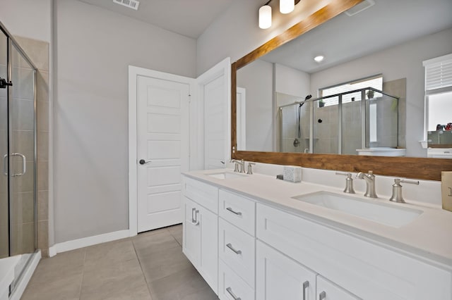 full bath with double vanity, visible vents, a stall shower, and a sink