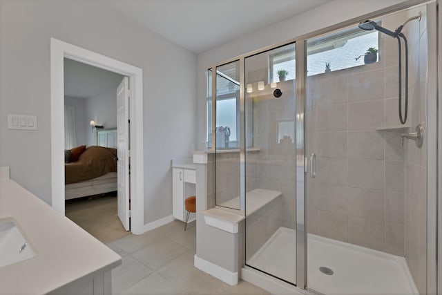 ensuite bathroom with a shower stall, connected bathroom, vanity, baseboards, and tile patterned flooring