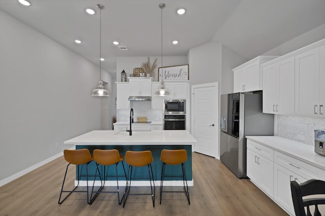 kitchen with stainless steel appliances, visible vents, decorative backsplash, and a kitchen bar