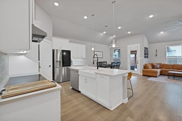1373 Silverthorn Trl, Justin, TX 76247 - kitchen with appliances with stainless steel finishes, a sink, wall chimney exhaust hood, vaulted ceiling, and light wood-type flooring