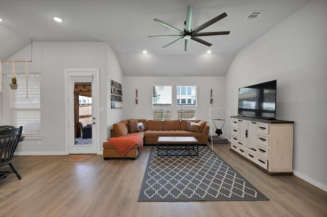 living area featuring a ceiling fan, wood finished floors, baseboards, lofted ceiling, and visible vents