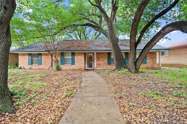 single story home featuring brick siding