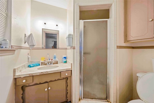 full bathroom featuring a stall shower, toilet, and vanity