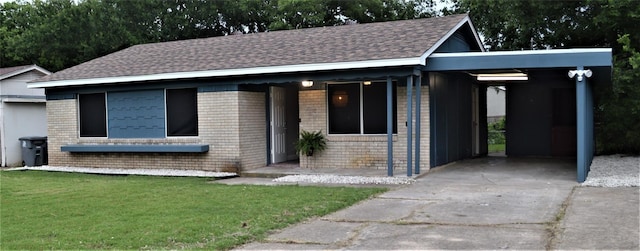 view of front of property featuring roof with shingles, a front lawn, an attached carport, concrete driveway, and brick siding