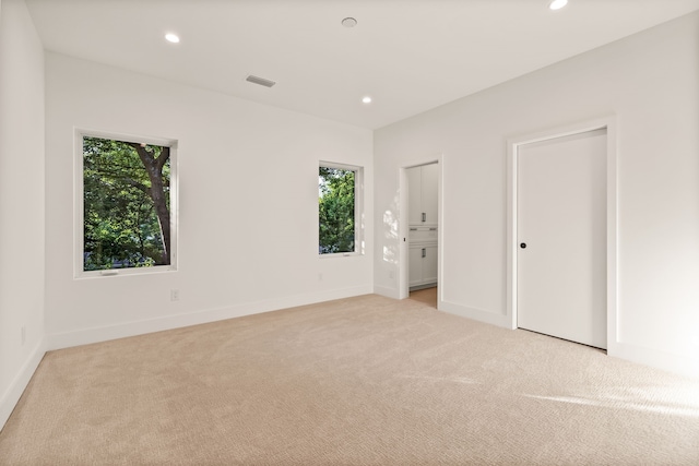 unfurnished room with recessed lighting and light colored carpet
