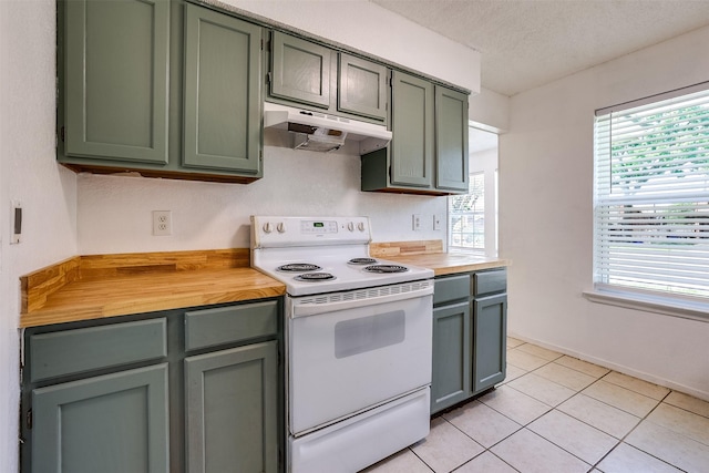 kitchen with electric range, under cabinet range hood, green cabinets, and butcher block countertops