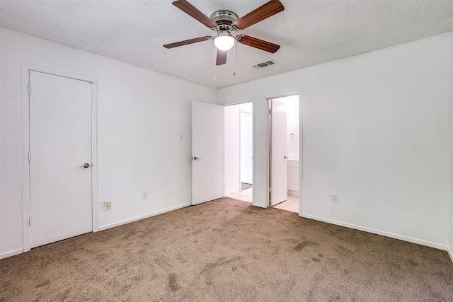 unfurnished bedroom with carpet floors, ensuite bathroom, visible vents, and baseboards