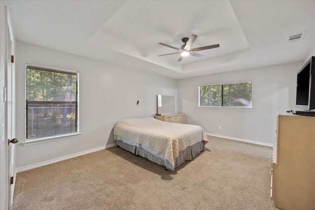 bedroom featuring a raised ceiling, carpet, visible vents, and baseboards