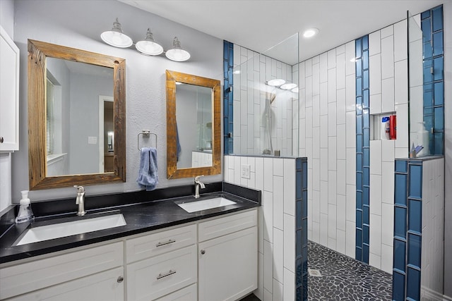 bathroom featuring recessed lighting, double vanity, walk in shower, and a sink