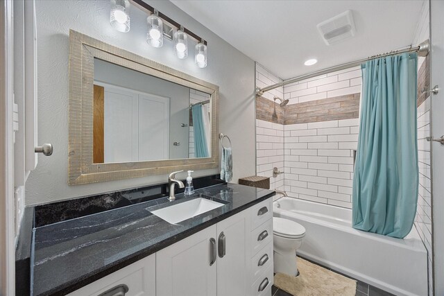 bathroom with shower / bath combination with curtain, toilet, vanity, and visible vents