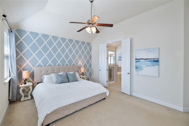 bedroom with ensuite bath, ceiling fan, baseboards, light colored carpet, and lofted ceiling