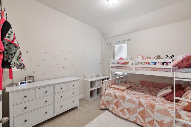 bedroom with lofted ceiling and light carpet