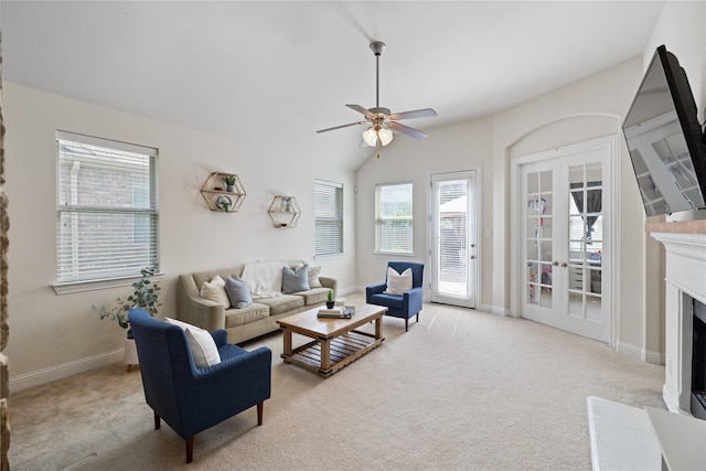 living room with a fireplace with flush hearth, light carpet, baseboards, lofted ceiling, and ceiling fan