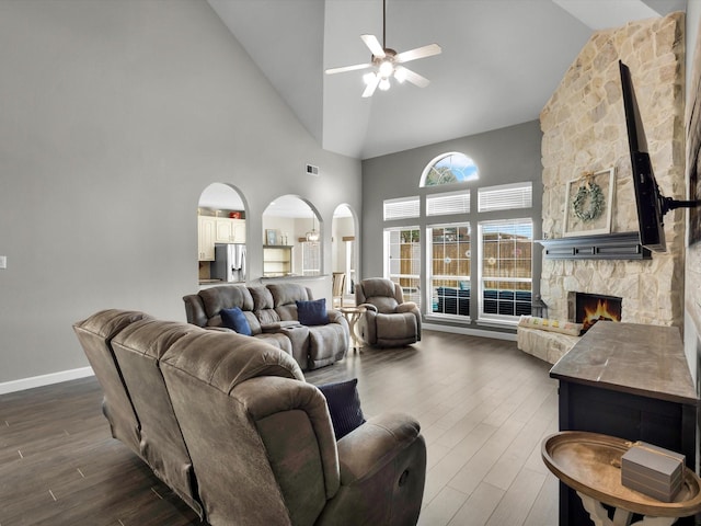1803 Timber Ridge Dr, Frisco, TX 75036 - living room with high vaulted ceiling, arched walkways, ceiling fan, dark wood finished floors, and a fireplace