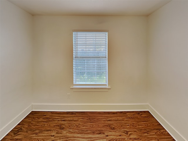 empty room featuring baseboards and wood finished floors