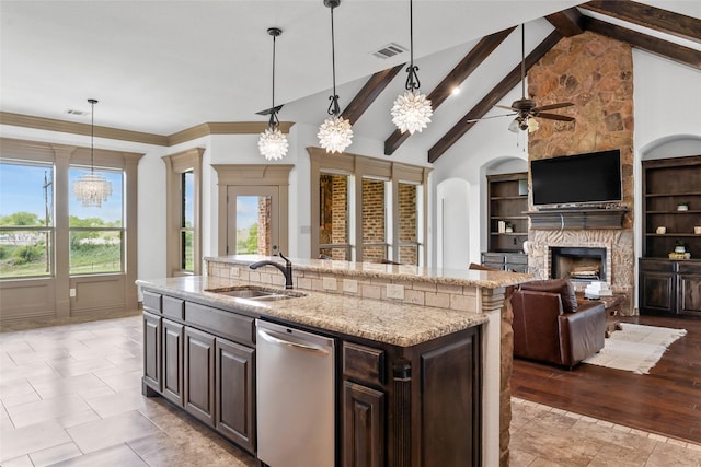 kitchen featuring dishwasher, light stone counters, a fireplace, and a sink