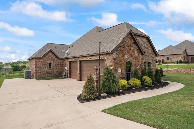 view of property exterior with a garage, fence, a lawn, central AC unit, and driveway