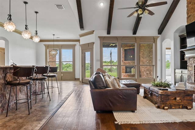 living room with hardwood / wood-style flooring, arched walkways, a ceiling fan, and visible vents