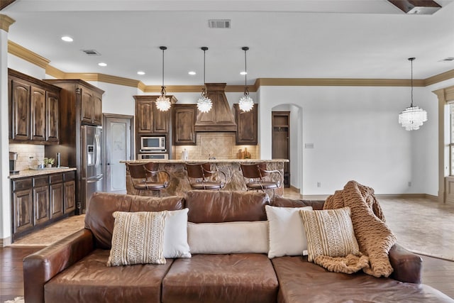 living area featuring arched walkways, baseboards, and visible vents