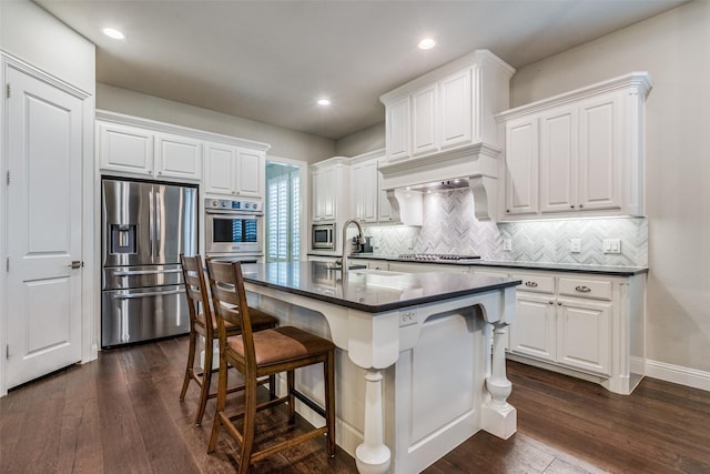 4011 Hollywood Park Ct, Celina, TX 75009 - kitchen featuring appliances with stainless steel finishes, dark countertops, dark wood-style flooring, decorative backsplash, and a sink