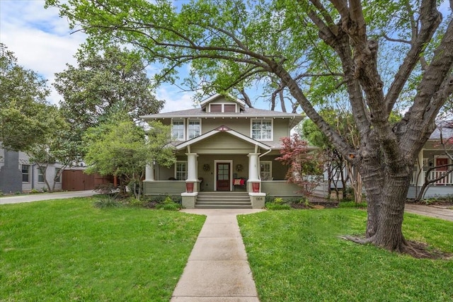 traditional style home featuring covered porch and a front yard