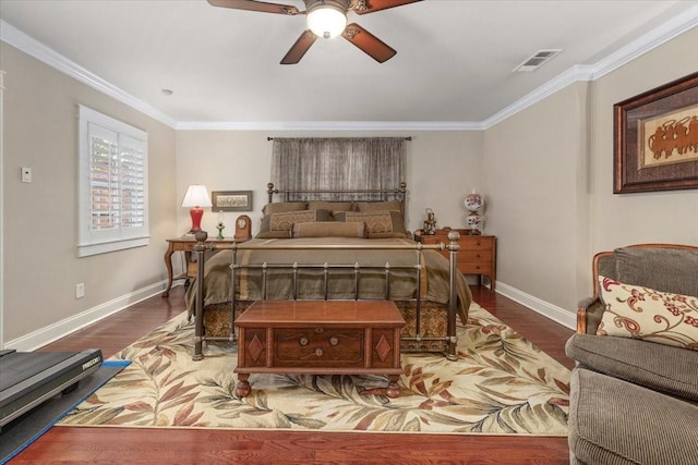 bedroom featuring baseboards, wood finished floors, crown molding, and ceiling fan