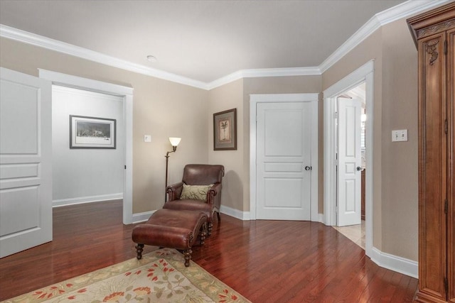 sitting room with wood finished floors, crown molding, and baseboards