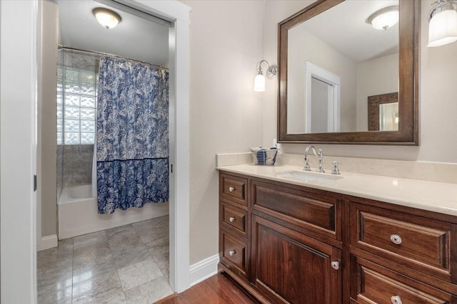 full bathroom with baseboards, vanity, and shower / bath combo
