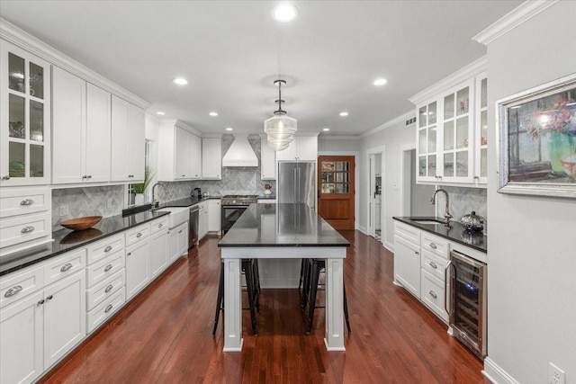 kitchen with premium appliances, custom range hood, wine cooler, a sink, and dark countertops