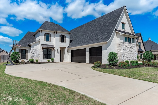 view of front of property with driveway, stone siding, a front yard, and a garage