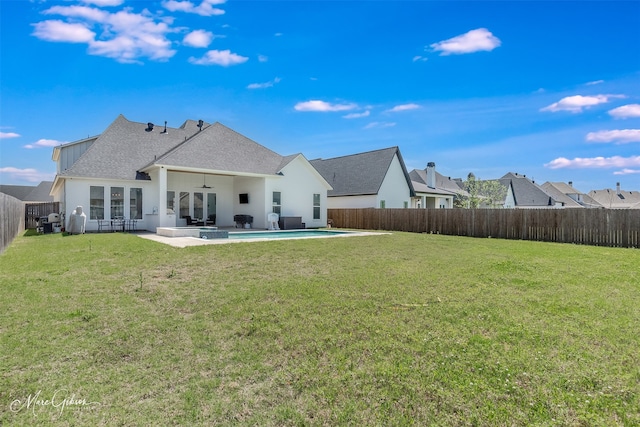 rear view of property featuring a fenced backyard, a yard, a ceiling fan, and a patio