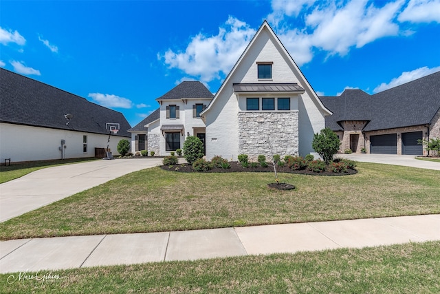view of front of home featuring stone siding, a standing seam roof, driveway, and a front yard