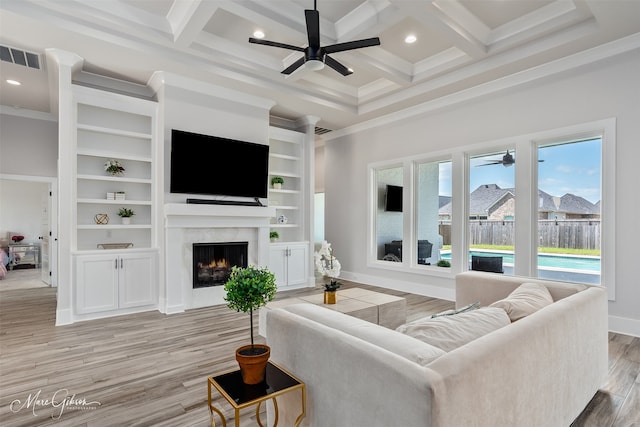 living area featuring ornamental molding, a high end fireplace, a ceiling fan, and visible vents